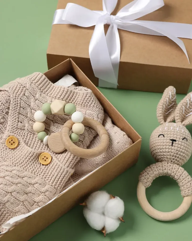 Dovanos kūdikiui ir naujagimiui – ekologiškas dovanų rinkinys su megztu smėlinuku, mediniu kramtuku su silikoniniais karoliukais, rankų darbo žaislu zuikučiu ir elegantiška dėžute su kaspinu. Natūralios medžiagos, praktiškos ir stilingos dovanos naujagimiams bei kūdikiams.